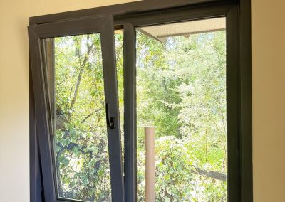 Ventana de PVC negra abierta en modo oscilobatiente