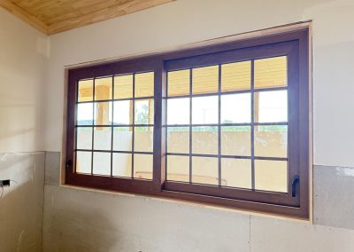 Ventana corredera de PVC color madera con cuadrícula, vista interior