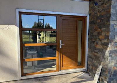 Ventana y puerta de PVC color madera en acceso de vivienda