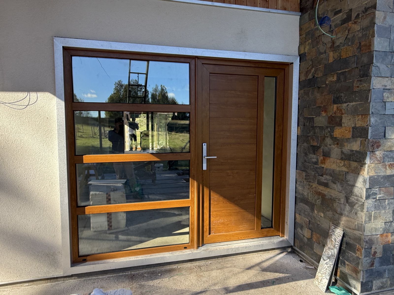 Ventana y puerta de PVC color madera en acceso de vivienda
