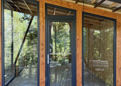 Cerramiento de terraza con ventanales y puerta de PVC negro