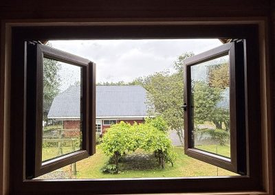 Ventana de PVC abatible abierta con vista al jardín
