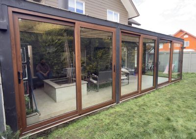 Quincho cerrado con ventanales de PVC color madera, vista exterior