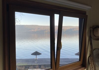Ventana de PVC color madera con vista al lago
